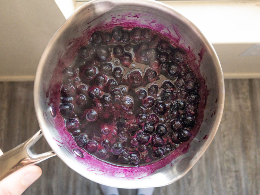 Boiling blueberries, honey, and lemon juice to make pectin free jam.