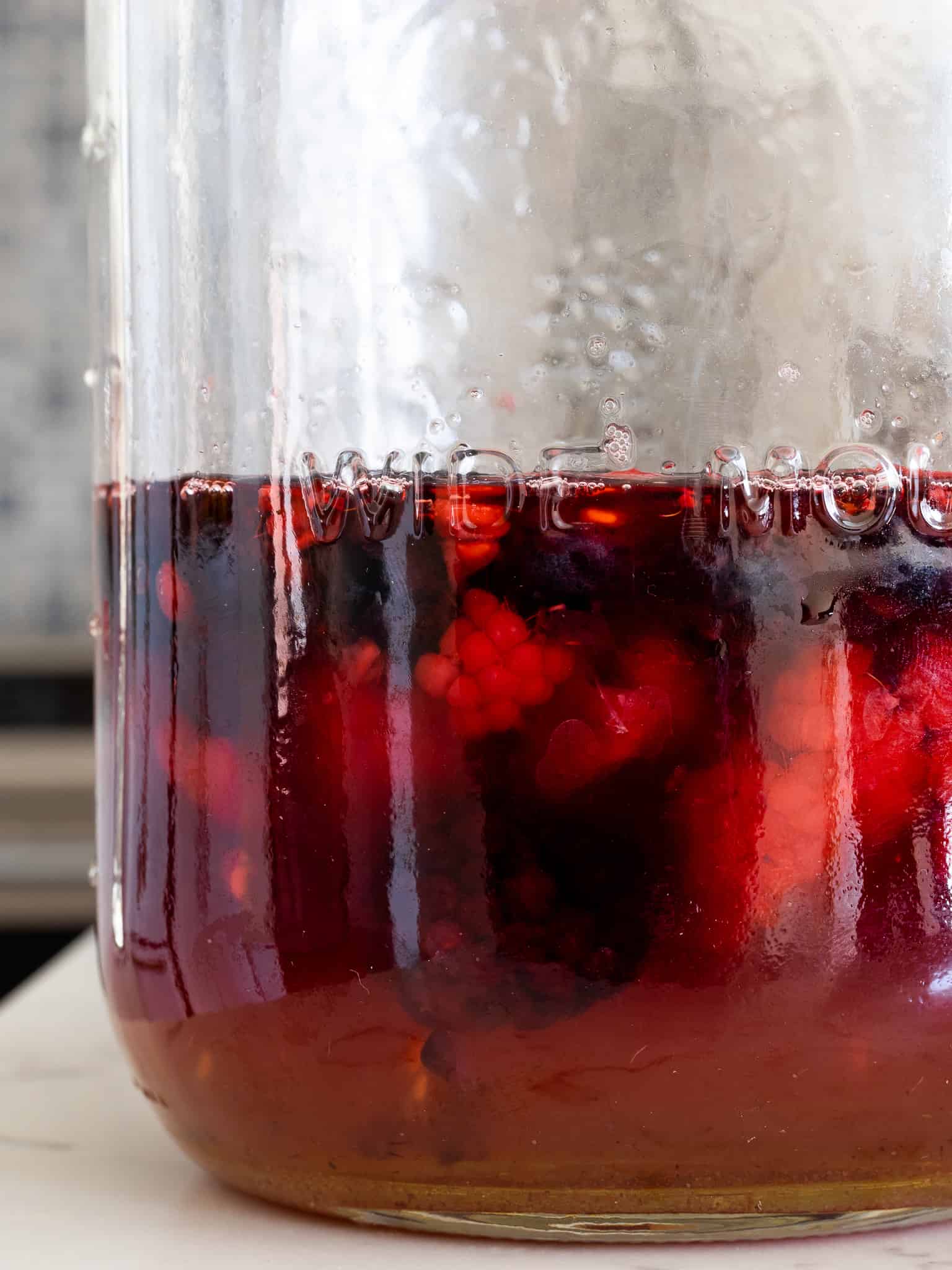 Fermented berries in a clean mason jar. It contains fermented blueberries, fermented raspberries, and fermented blackberries.