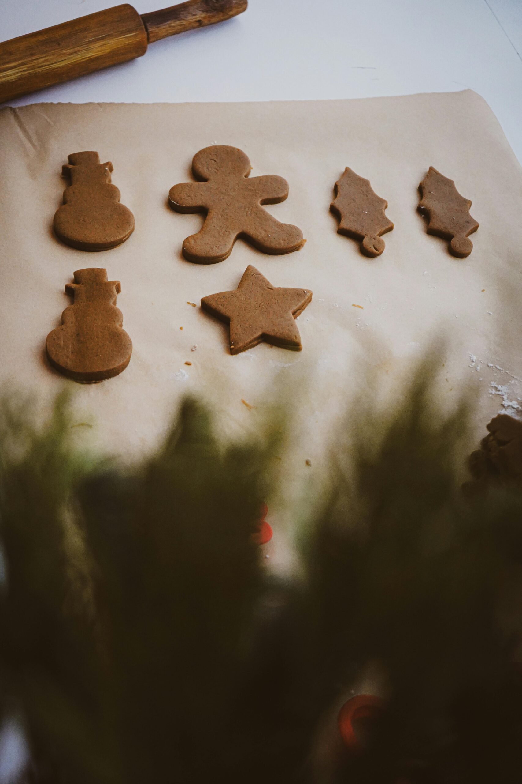 Rustic sourdough gingerbread dough being rolled out and cut into holiday shapes in a farmhouse kitchen.