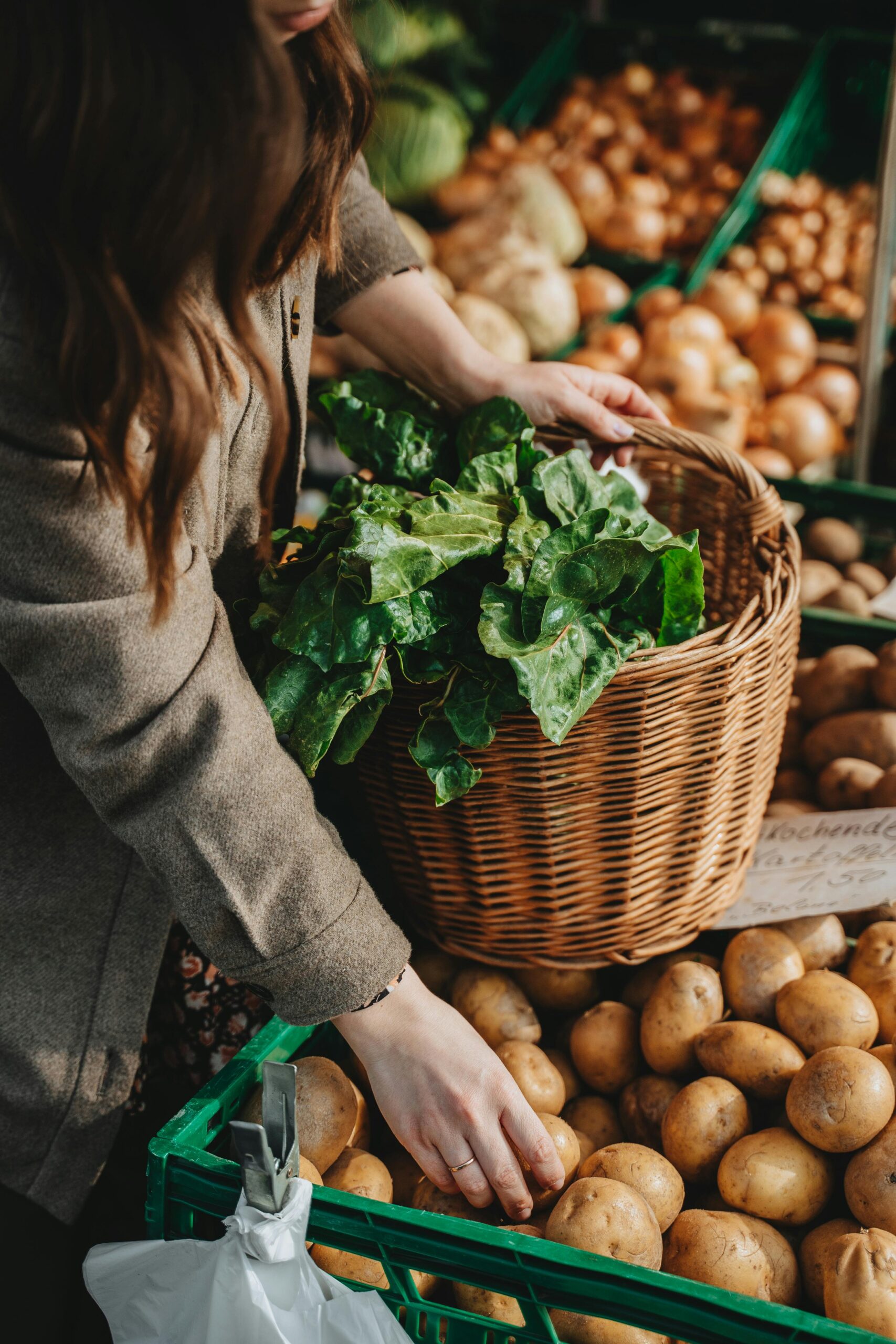 A woman selling produce at the farmers market which are beginner friendly homestead side hustles and small homestead income ideas