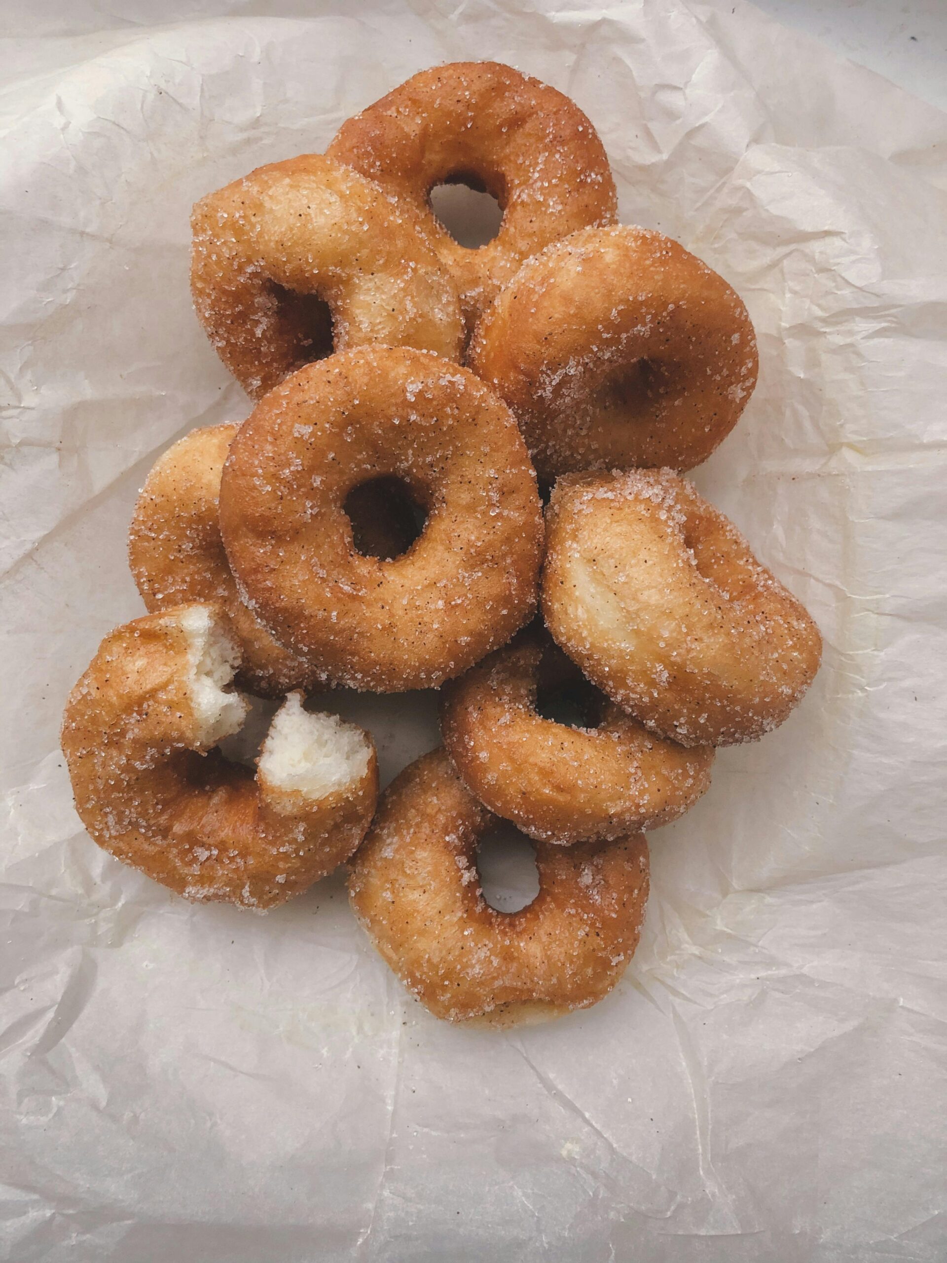 Homemade sourdough donuts that are covered in cinnamon and sugar, that are baked sourdough donuts