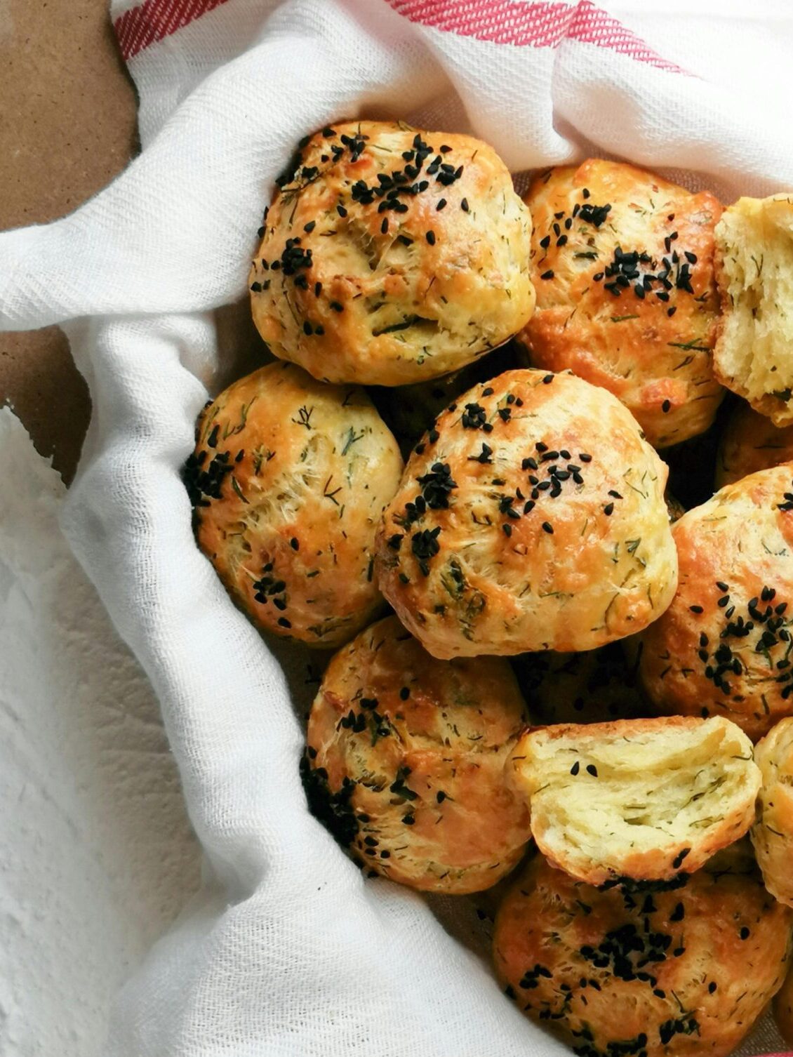 An up close view of homemade sourdough biscuits in a basket, a type of rustic sourdough baking