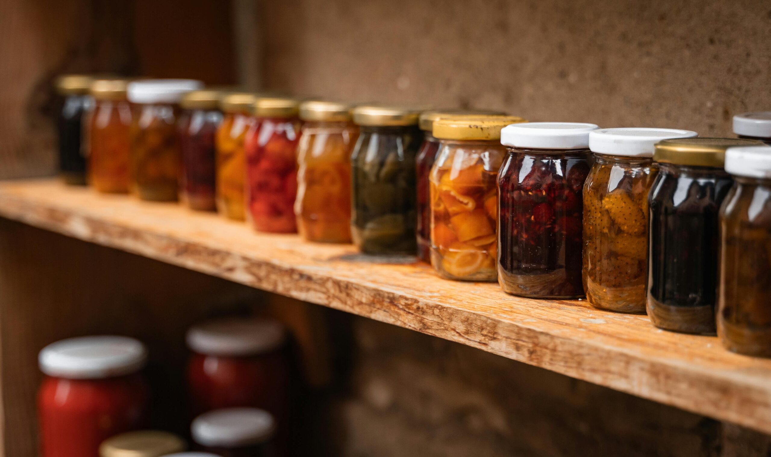 A shelf full of canning jars for home canning ideas showing what foods can be canned