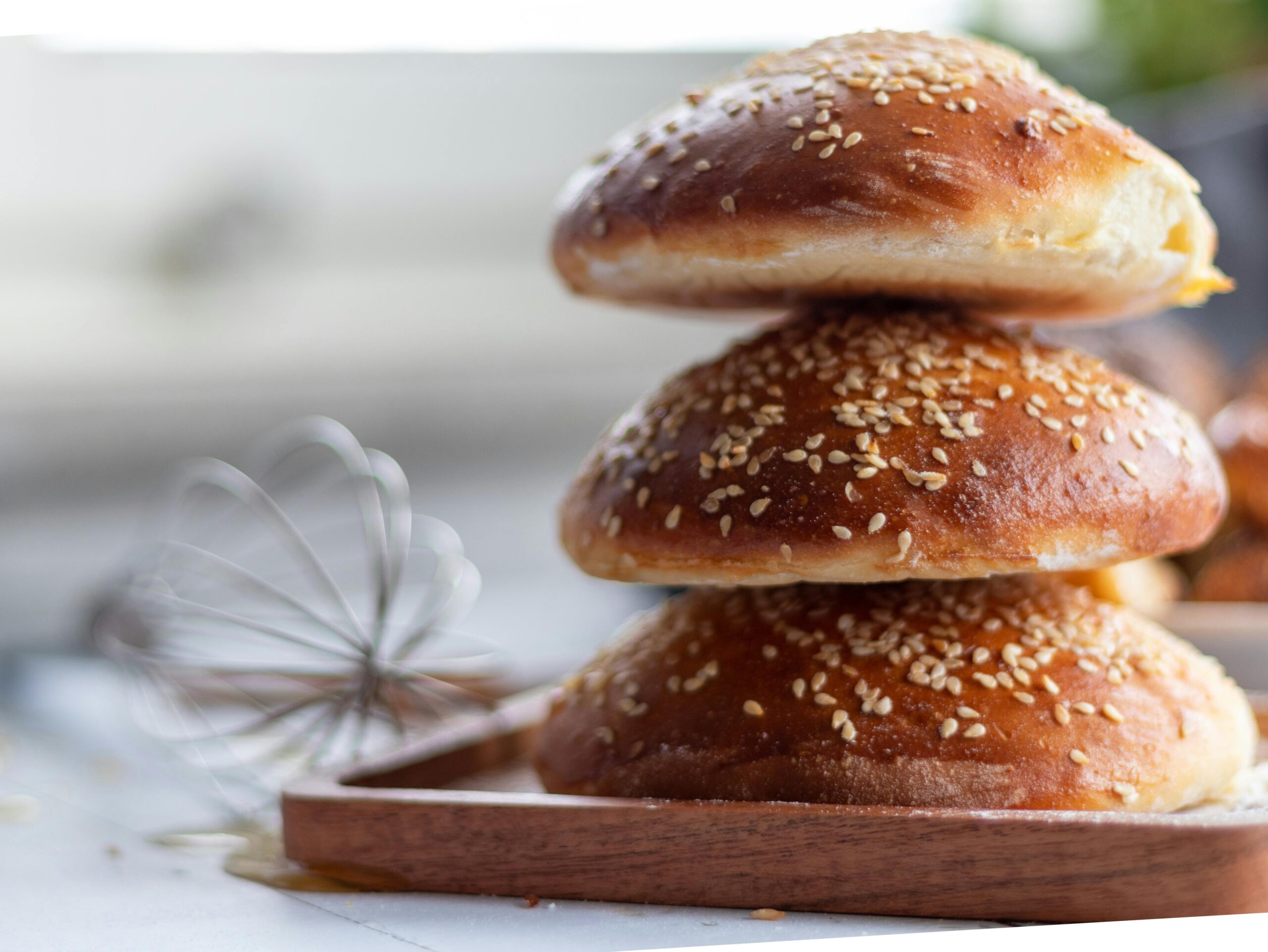 A stack of soft sourdough buns showing how to make sourdough hamburger buns from scratch
