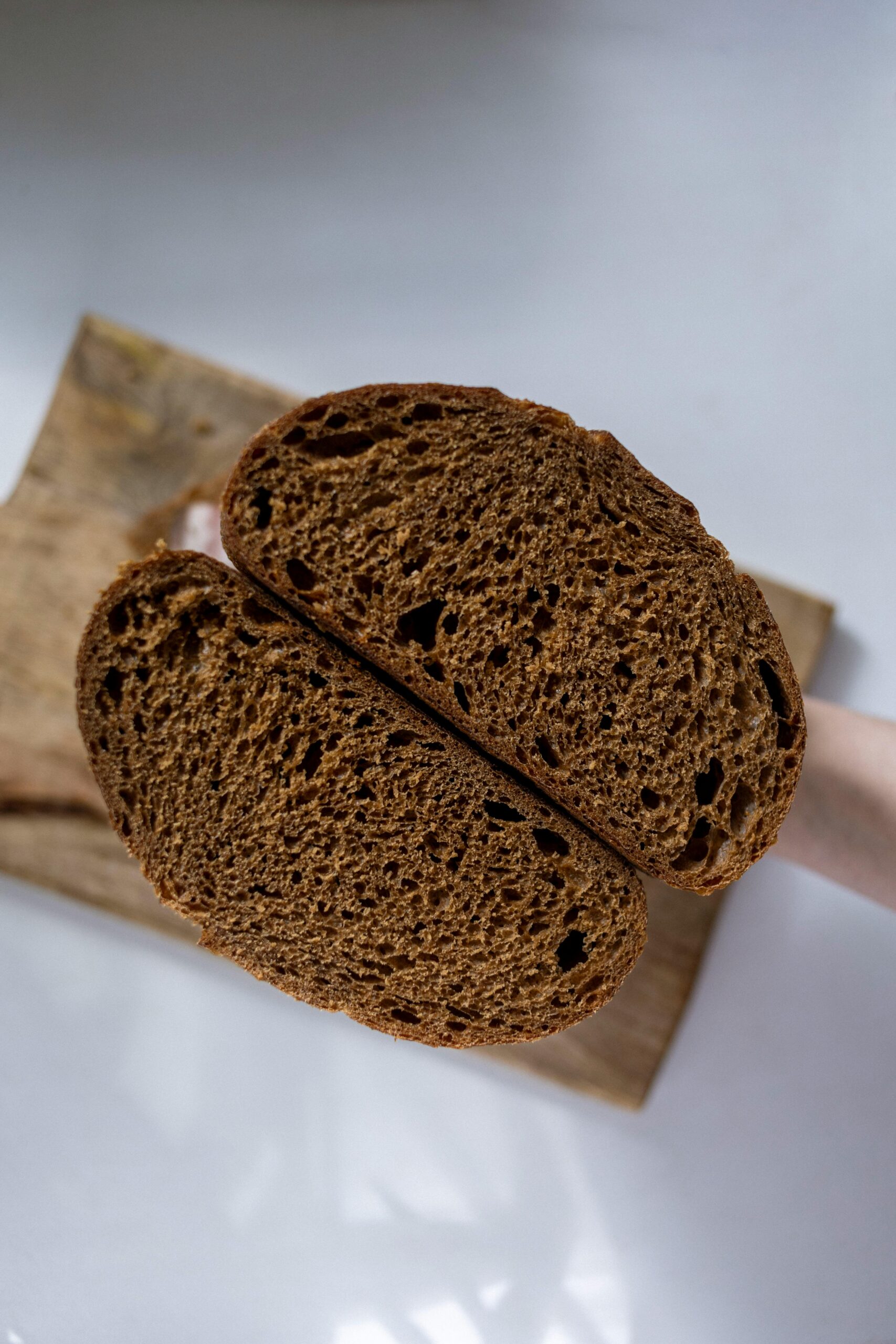 Sourdough pumpernickel bread sliced in half, a pumpernickel sourdough