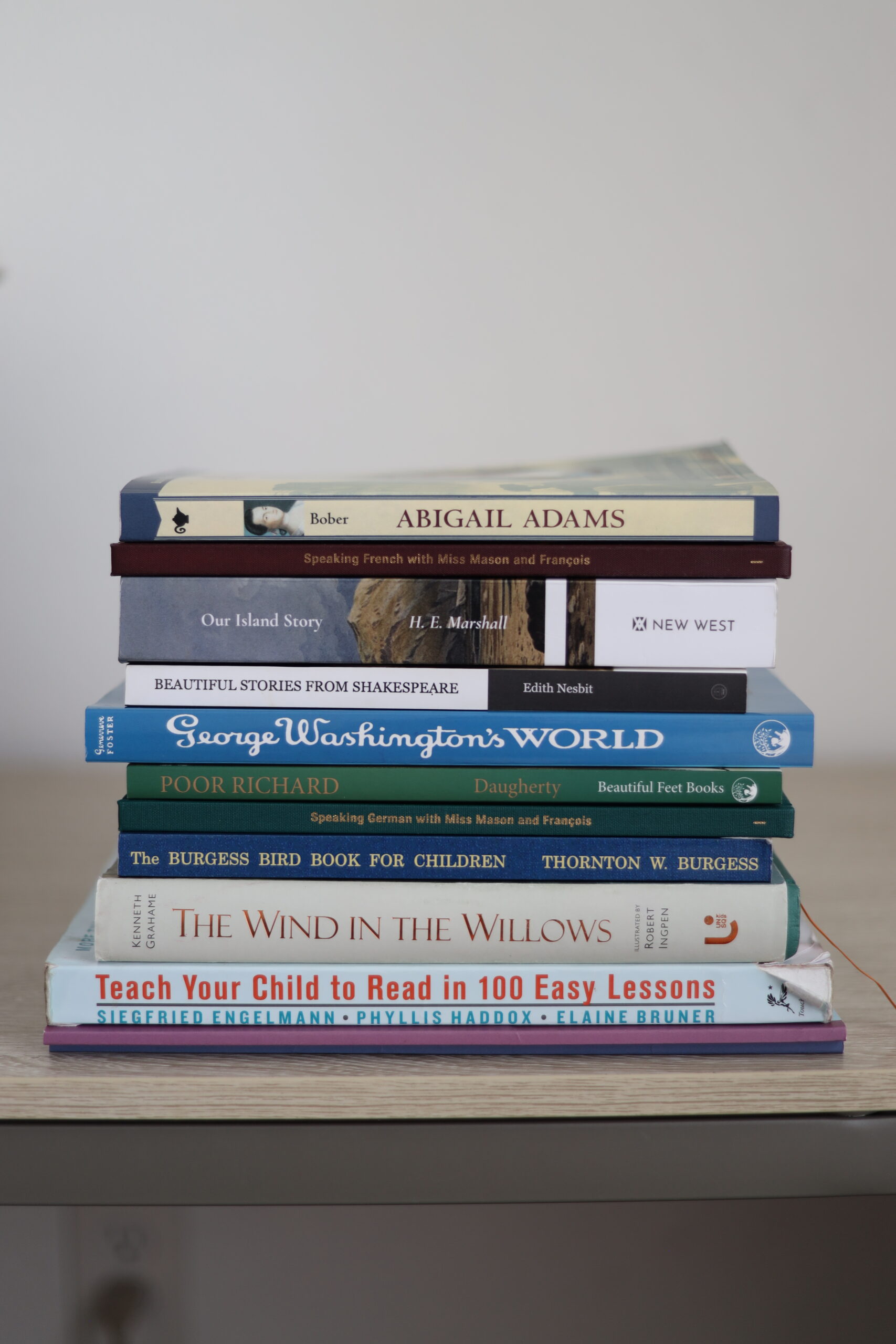 A stack of books in a living books homeschool  with a homeschool curriculum review
