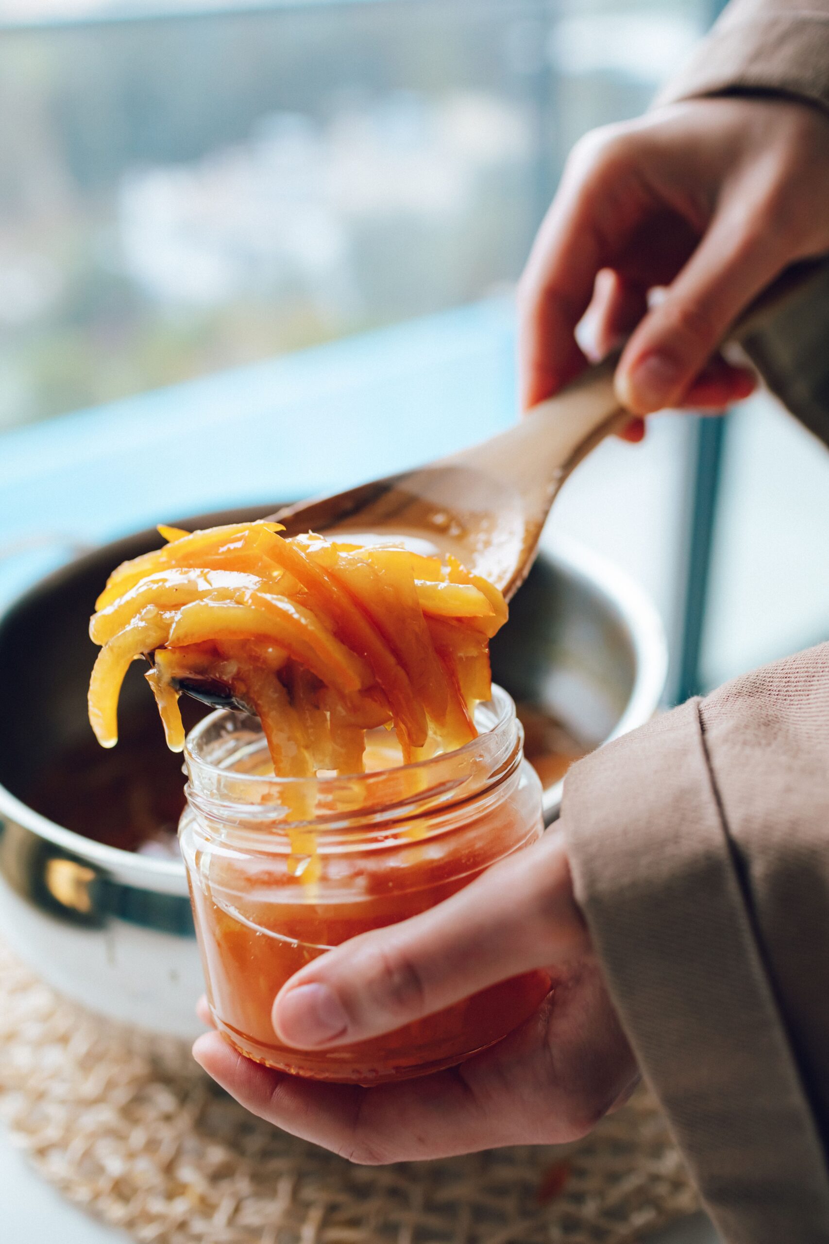 Spooning orange peel in a orange marmalade recipe, an easy homemade orange marmalade recipe