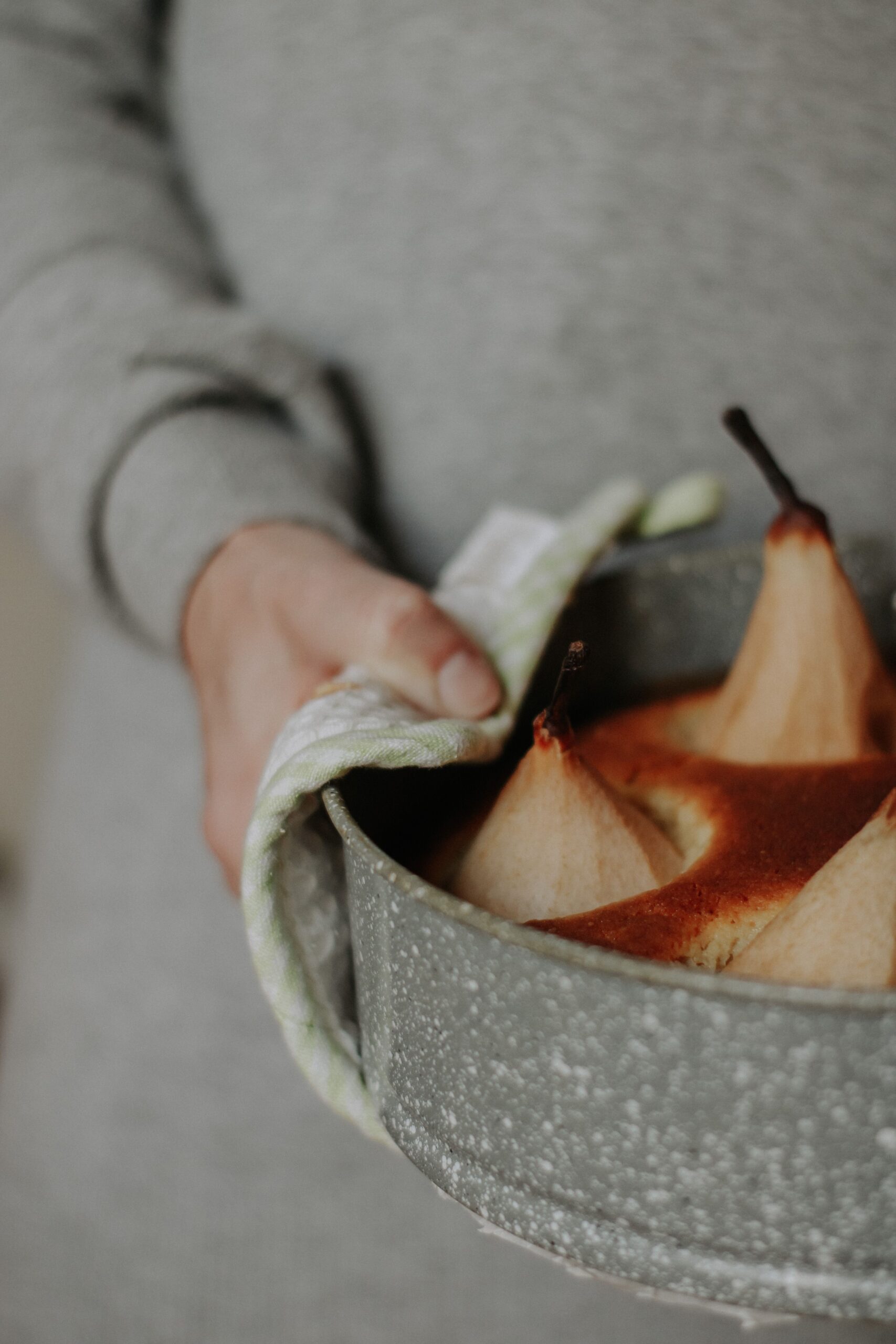 A woman holding pear frangipane tart, an almond pear tart with sourdough discard